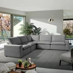 a living room filled with furniture and large windows