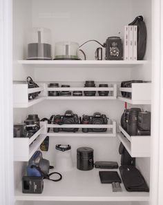 there are many cameras on the shelves in this room, and one is open to show it's contents