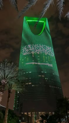 a very tall building lit up with green lights