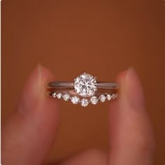 a close up of a person holding a ring with a diamond on it's side