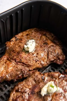 three steaks cooking on top of a grill with butter and herbs in them,