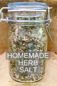 homemade herb salt in a glass jar with the words homemade herb salt above it on a wood background