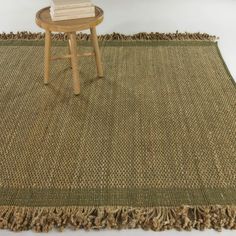 a table and chair on a woven rug