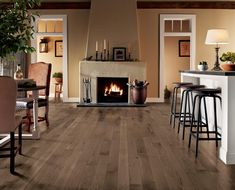 a living room filled with furniture and a fire place next to a kitchen counter top