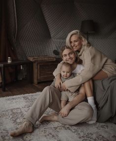 a woman sitting on top of a bed holding a baby