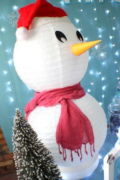 a paper snowman with a red hat and scarf