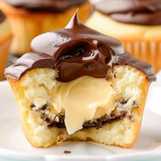 cupcakes with frosting and chocolate on top sitting on a plate