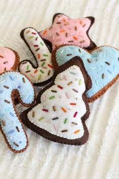 four decorated cookies sitting on top of a bed