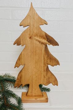 a wooden christmas tree with pine needles