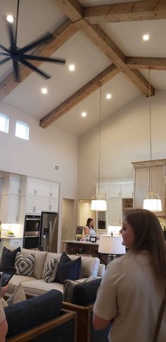 a woman standing in a living room next to a kitchen