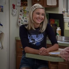 two women sitting at a kitchen counter talking to each other