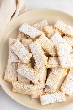 powdered sugar cubes in a bowl on a white table cloth next to a napkin