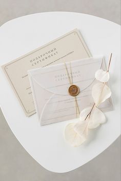 the wedding stationery is laid out on a white table