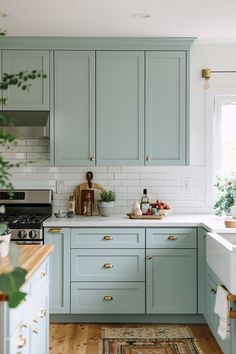 a kitchen with light blue cabinets and white counter tops is seen in this image from the doorway