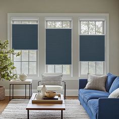 a living room filled with furniture and windows covered in blue blind shades on the windows