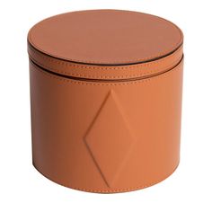 a round leather box with a diamond design on the front and bottom, sitting on a white surface