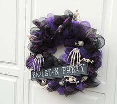 a purple and black wreath with skeleton decorations on it that reads skelet - n - party