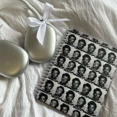 an open notebook with black and white photos on it next to two eggs in a vase