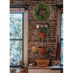 a brick wall with plants hanging from it's sides and a window in the background