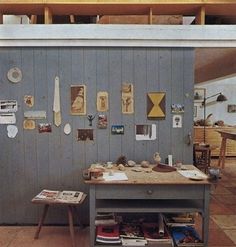 a table with many items on it in front of a wall covered in magnets and pictures