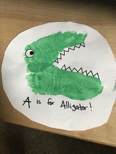 a paper plate that has a drawing of a crocodile on it with the words a is for alligator