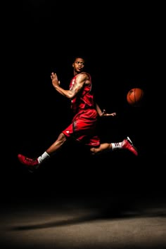 a basketball player is in the air with his foot up as he dribbles