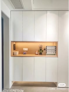 a kitchen with white cupboards and counter tops in the middle of an empty room