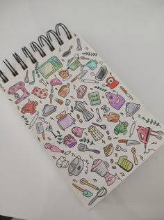 a spiral notebook with doodles on it and various kitchen related items in the pages