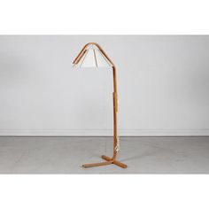 a wooden floor lamp with a white shade