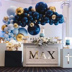 balloons are hanging from the ceiling in front of a table with an x and m sign on it