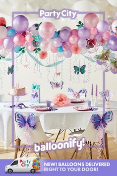 balloons and streamers are hanging from the ceiling above a table with a cake on it