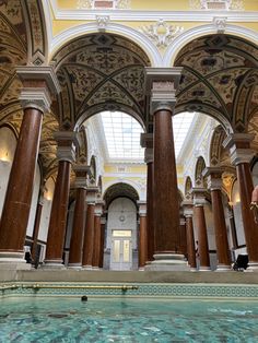 an indoor swimming pool with columns and arches