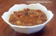 a white bowl filled with beans on top of a wooden table