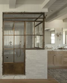 a bathroom with a glass shower door next to a sink