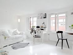 a white living room filled with furniture and decor