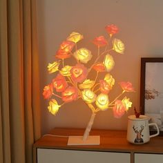 a lamp that is sitting on top of a table next to a vase with flowers in it