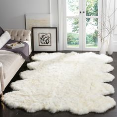 a living room with a white rug on the floor and a couch next to it