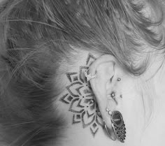 a woman's ear with a tattoo on it