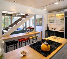 a kitchen with a stove top oven sitting under a stair case