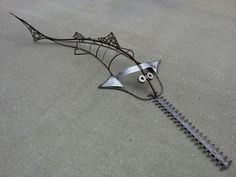 a metal sculpture that is laying on the ground