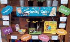 the curiosity cube display is filled with toys and books for children to read or write