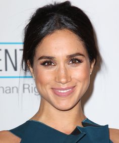 a close up of a person wearing a blue dress and smiling at the camera with her eyes closed