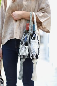 a woman is holding two purses on her shoulder