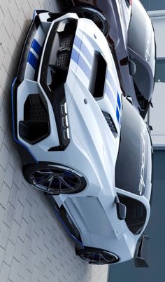 an aerial view of two sports cars parked next to each other on a brick wall