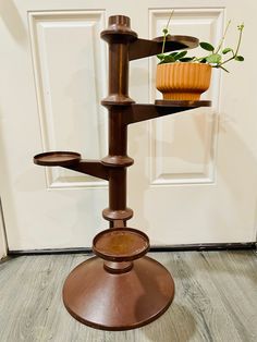 a potted plant sitting on top of a metal stand in front of a door