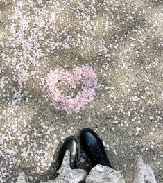 someone is standing on the sidewalk with their feet in the air and pink confetti