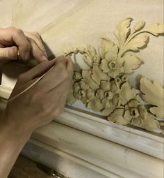 a person is working on a piece of art with wood shavings and paint