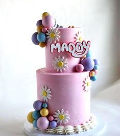 a pink cake with flowers and letters on it