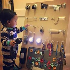 a little boy standing next to a display with keys and lights on it's sides