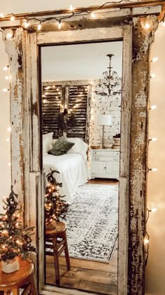 an old door is decorated with christmas lights and garlands for the holiday decor in this bedroom